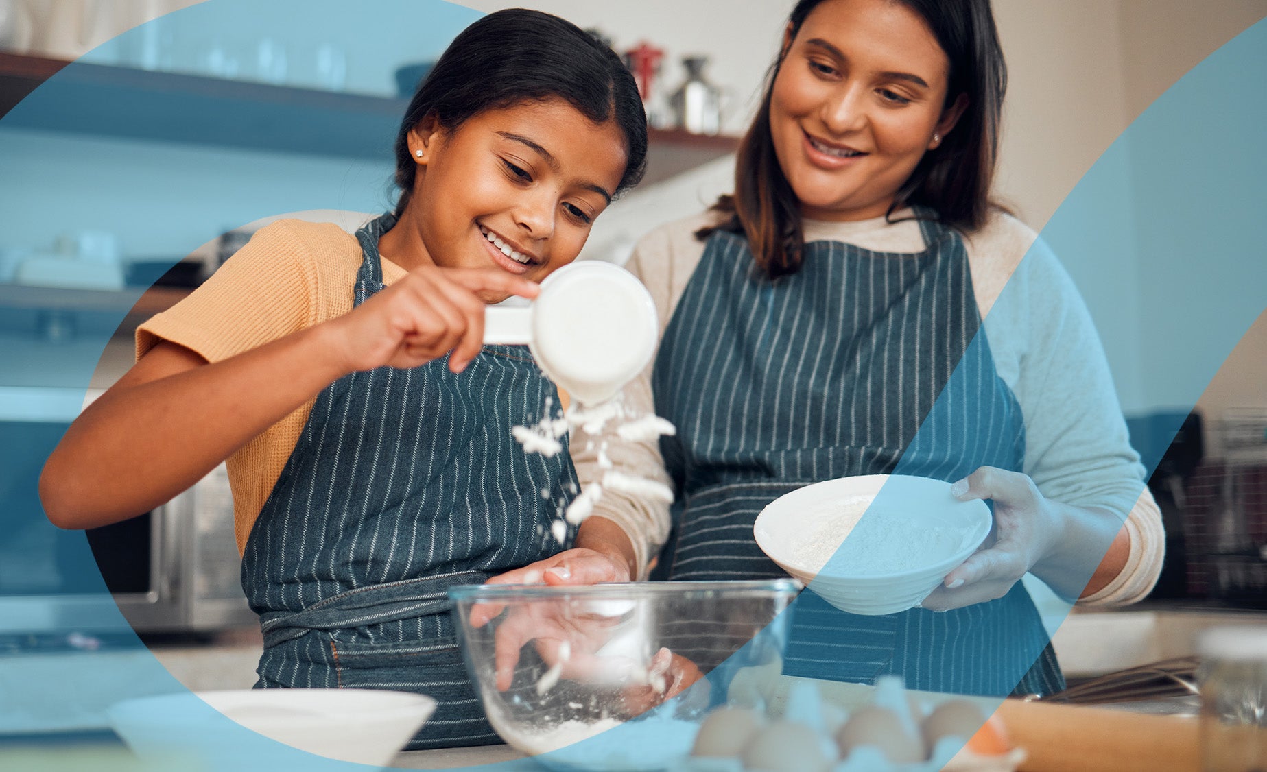 A little girl helps her mother sieve some flour into a mixing bowl