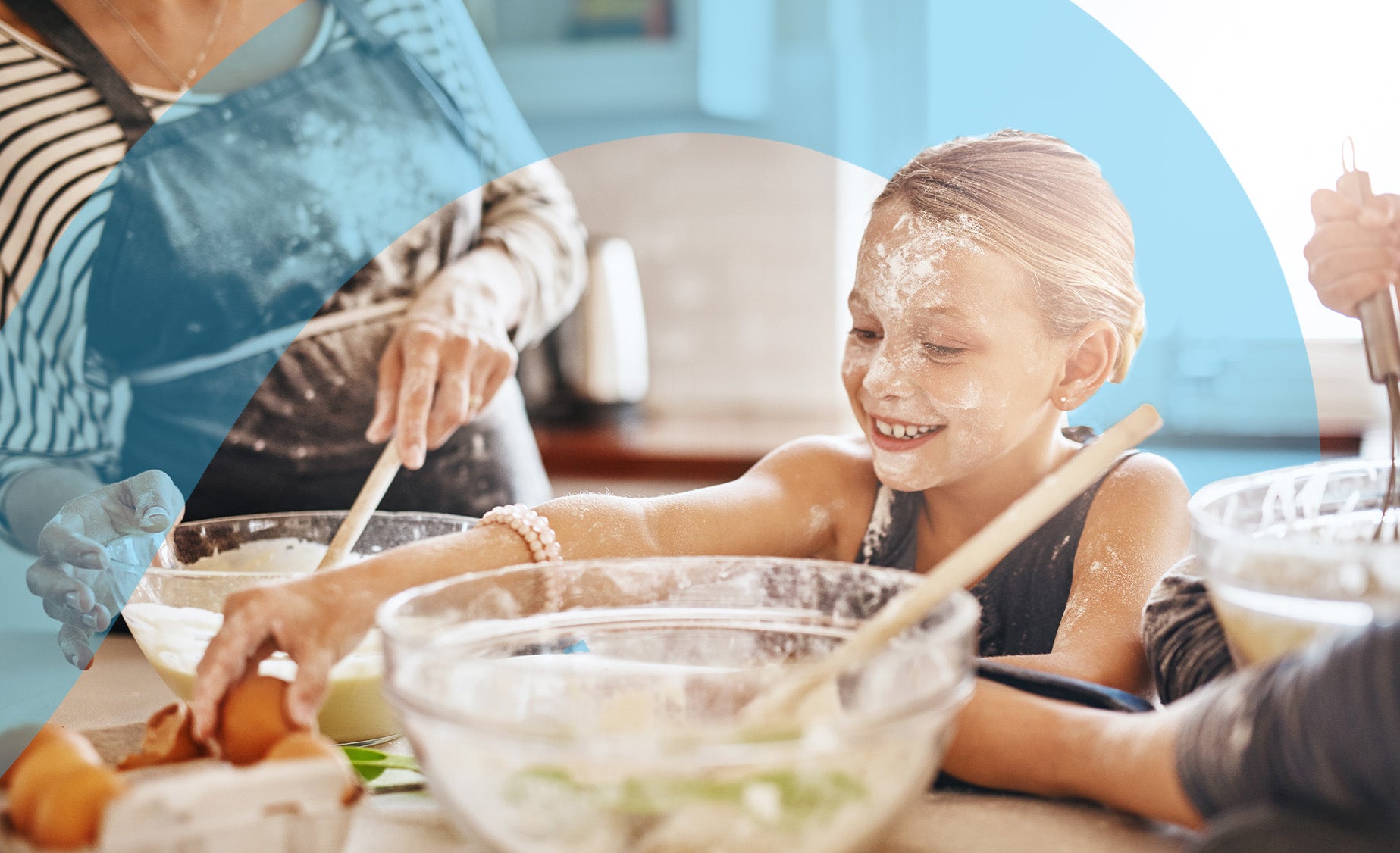 Child enjoying messy baking with guardian in background