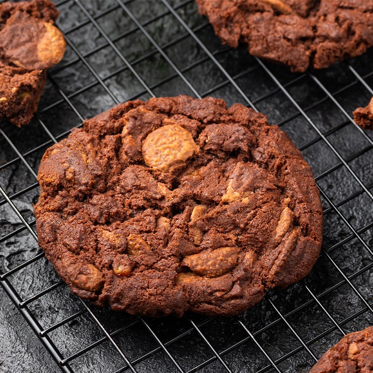 Chocolate cookies with chunks of Aero Orange on a wire rack