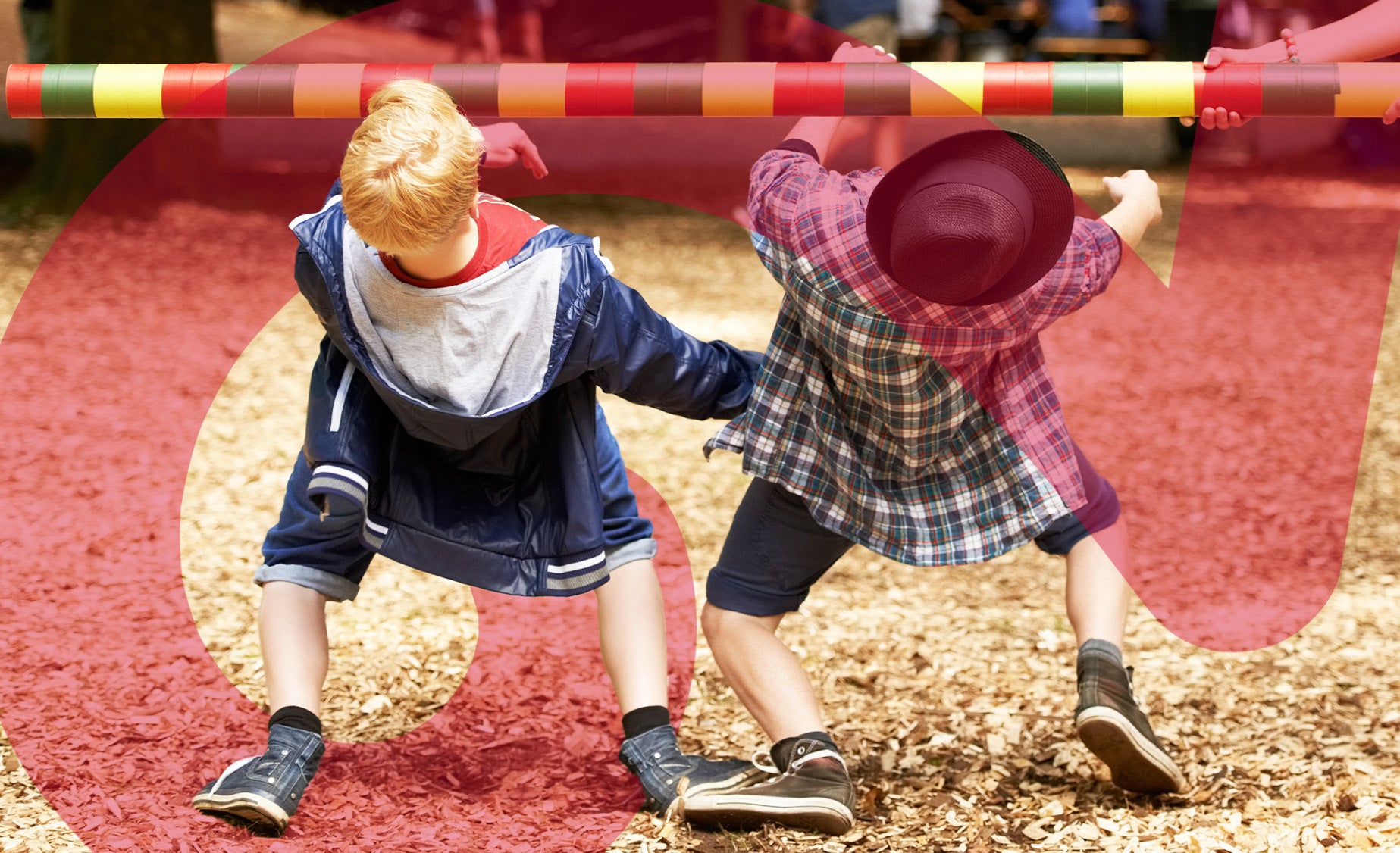 Two children doing limbo under a colourful stripy bar, being held by an adult