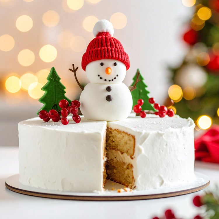 Vanilla cake with white chocolate buttercream topped with model of snowman with red hat, berries and little fir trees on whit
