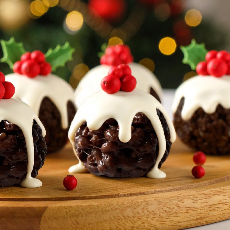 Mini chocolate rice crispy cakes shaped into balls and decorated with fondant icing to look like little Christmas puddings, d