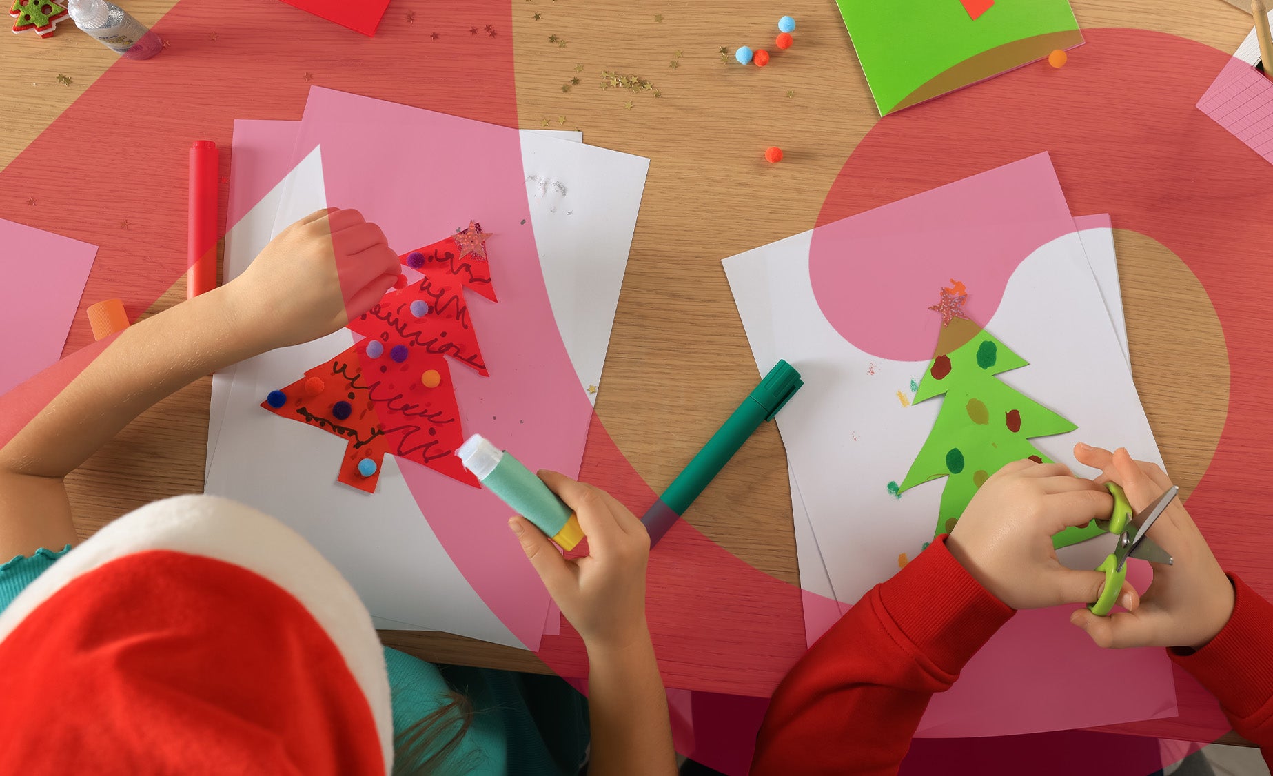 Children crafting Christmas cards using colorful paper and scissors at a festive table filled with art supplies.
