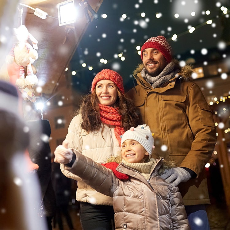 Couple with child enjoying Christmas lights