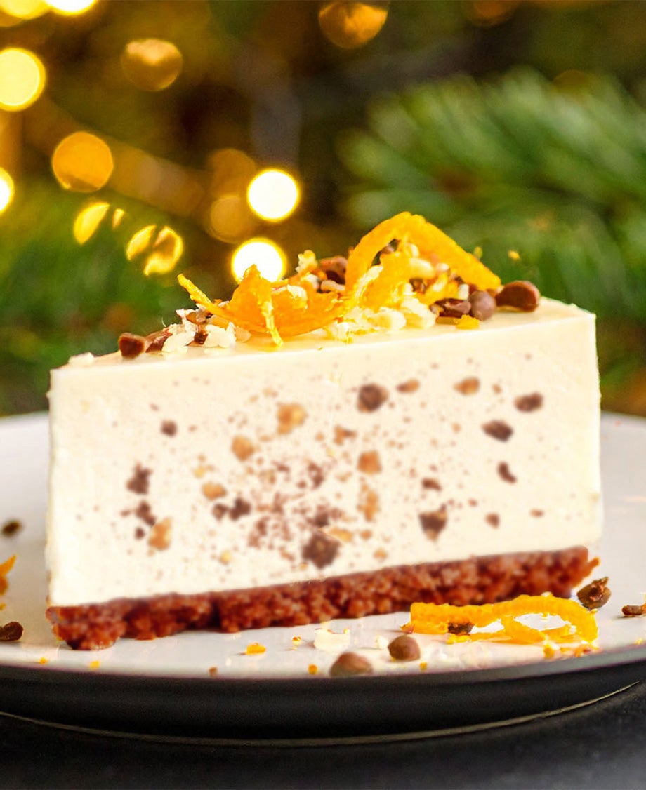 Slice of Christmas cheesecake with a speckled fruit mincemeat folded through the filling and grated orange zest on the top.