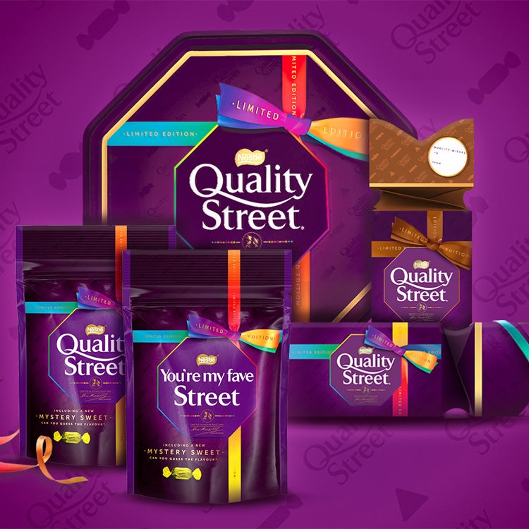  Arrangement of Quality Street tin, pouches, carton and cracker against a branded purple background.