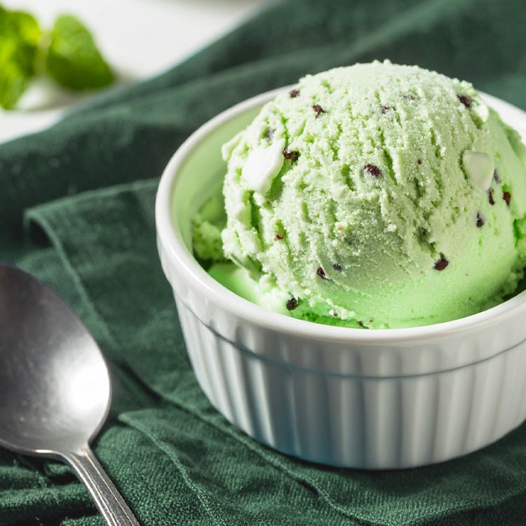 Scoop of After Eight mint ice cream in a small white ramekin on a green napkin with teaspoon