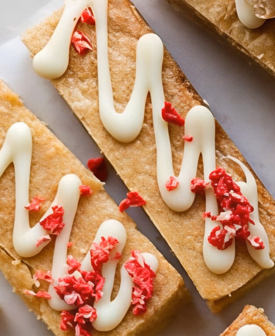 Shortbread slices with Milkybar white chocolate drizzled on them and sprinkled with freeze-dried strawberries.