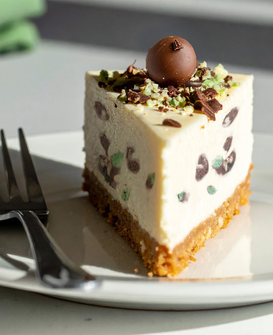 A slice of Aero® Chocolate Cheesecake on a white plate, accompanied by a silver fork resting beside it.