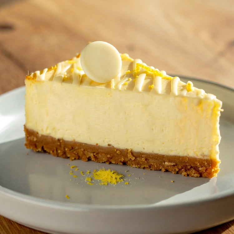 A slice of lemon and white chocolate cheesecake with grated lemon rind