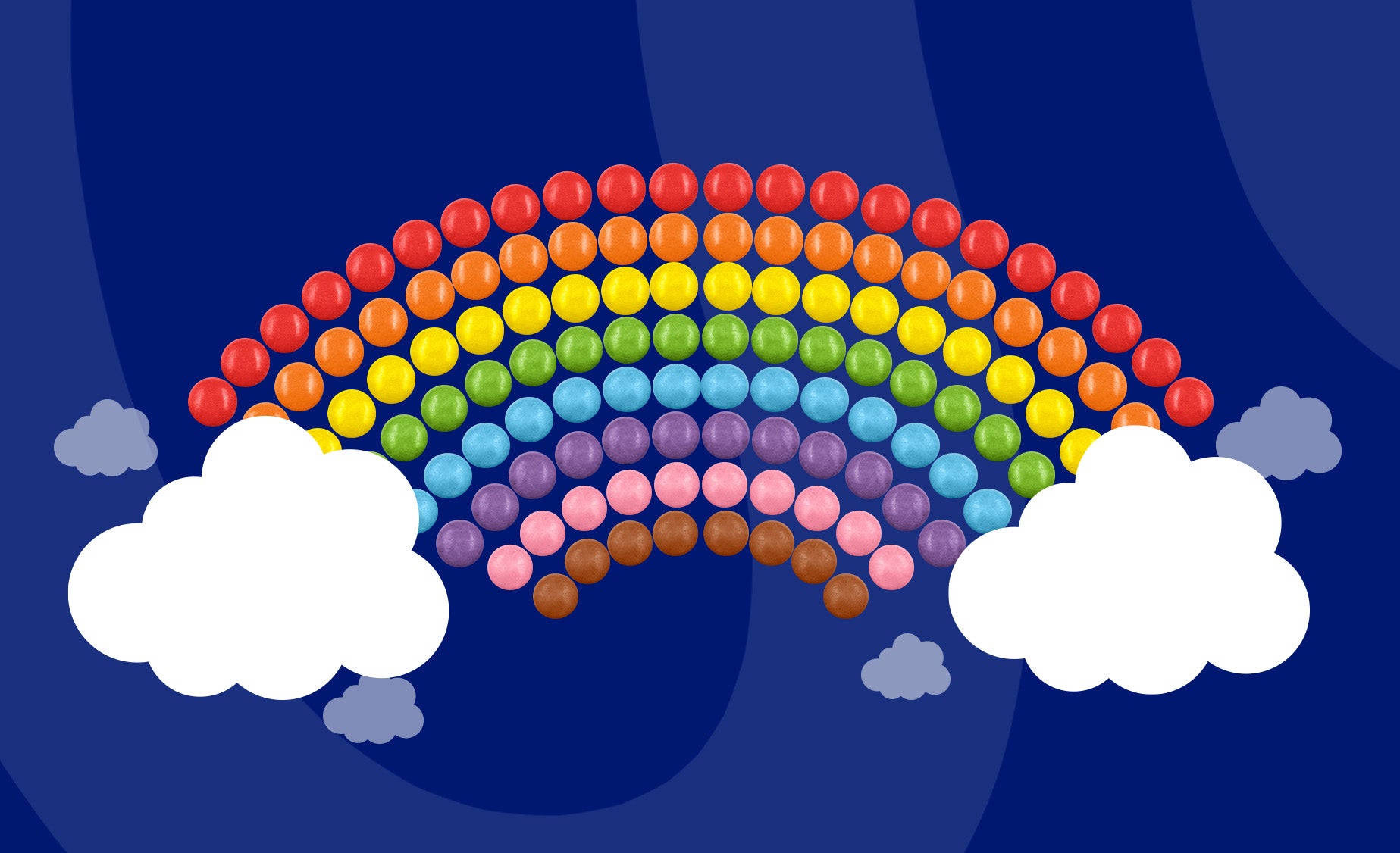 Colourful Smarties arranged in a rainbow picture, with white clouds at either end. 