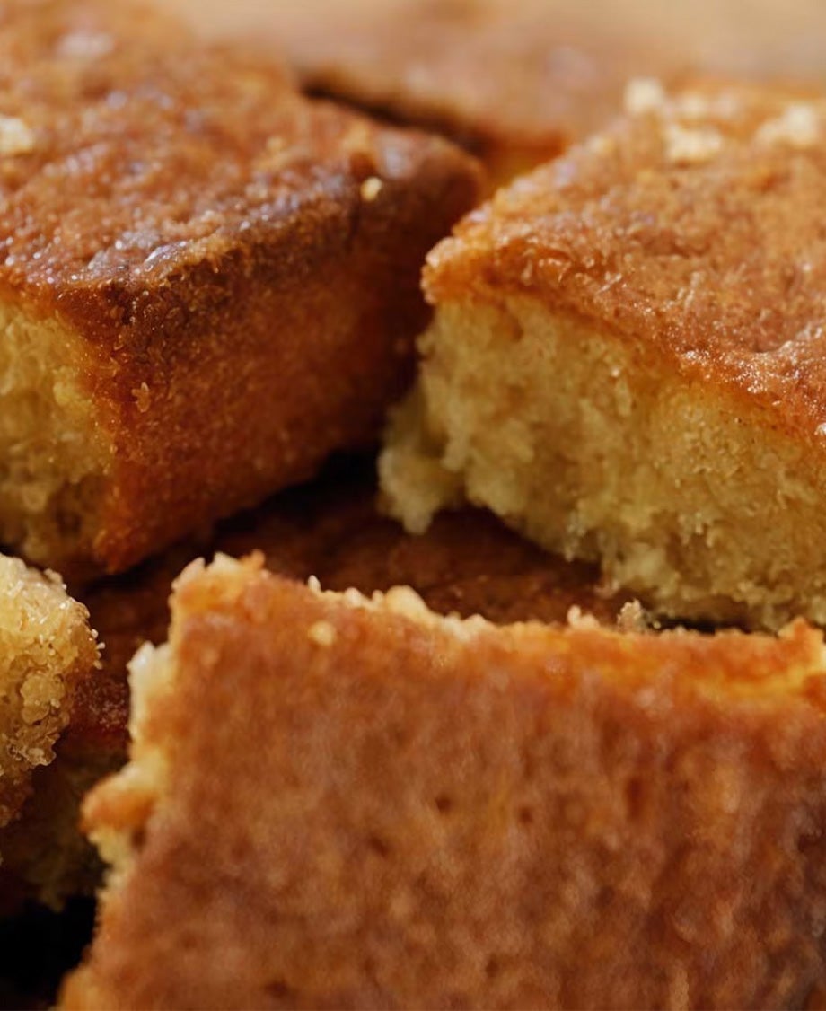 Squares of soft Milkybar white chocolate blondies on a wooden board 