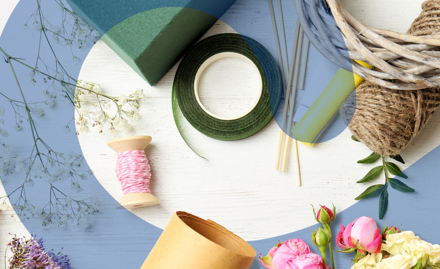 Overhead shot of bouquet crafting ingredients, including jute string, a green ribbon and some flowers 