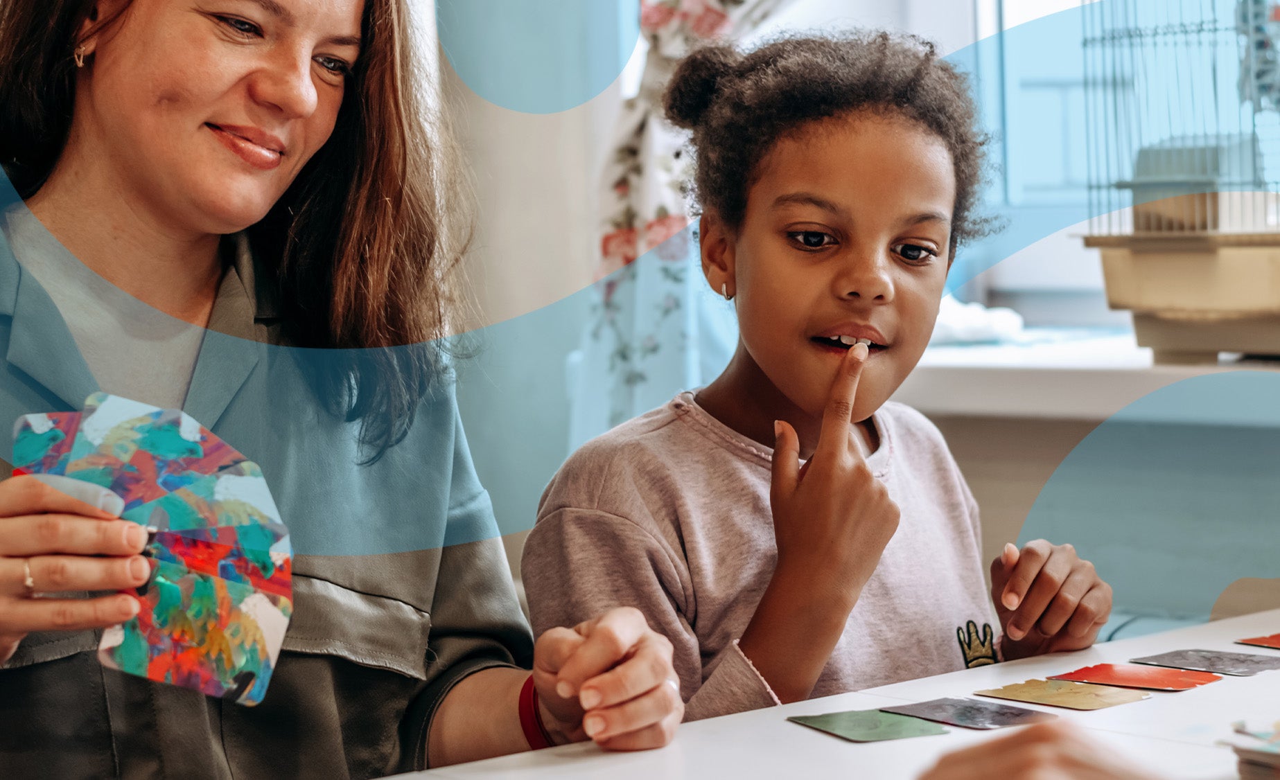 A woman and her daughter playing a colourful card game at a table