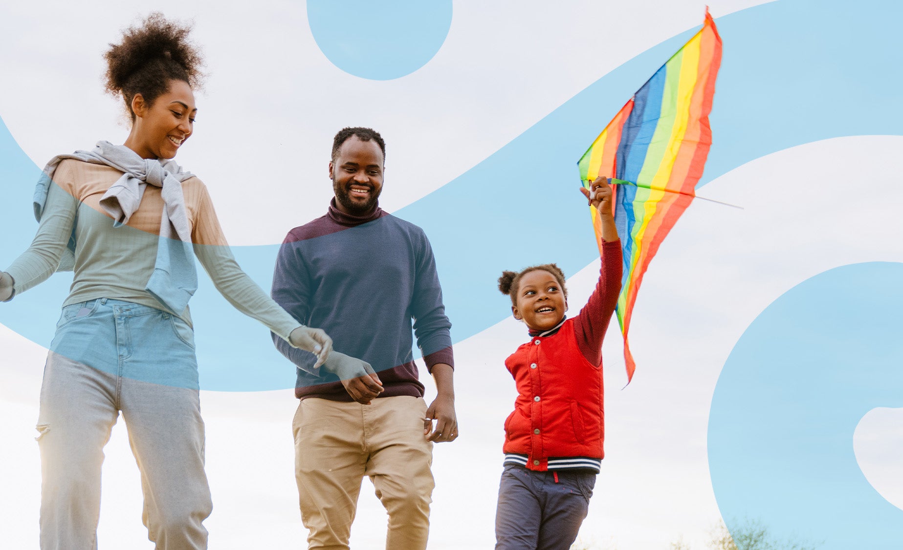  A smiling woman, man and their daughter fly a kite on a cloudy day 