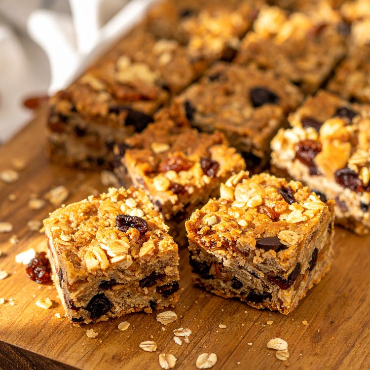 Golden squares of flapjacks made with Yorkie Raisin and biscuit, on a wooden board 