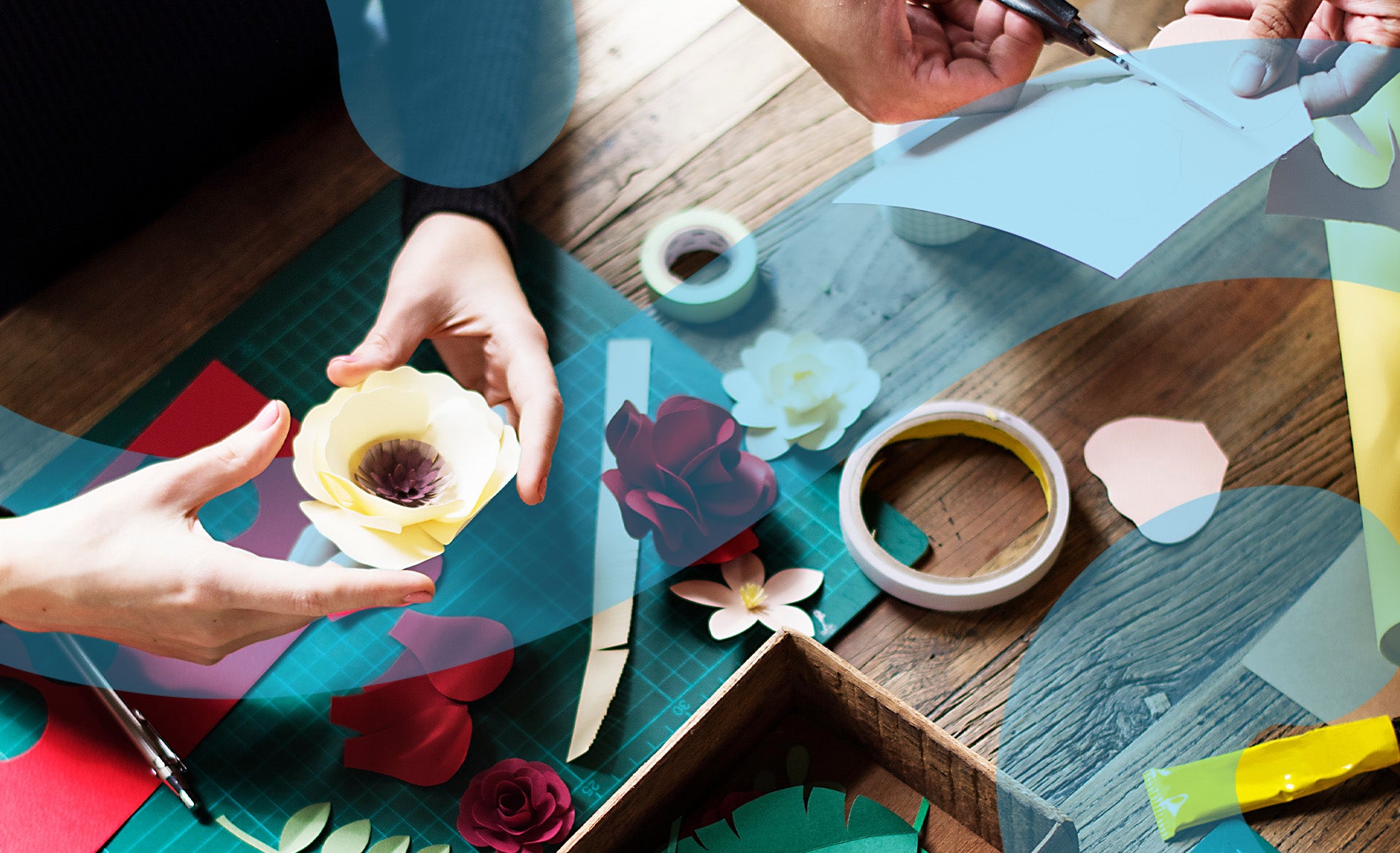 Wooden Easter craft table with paper flowers, sticky tape and scissors. 