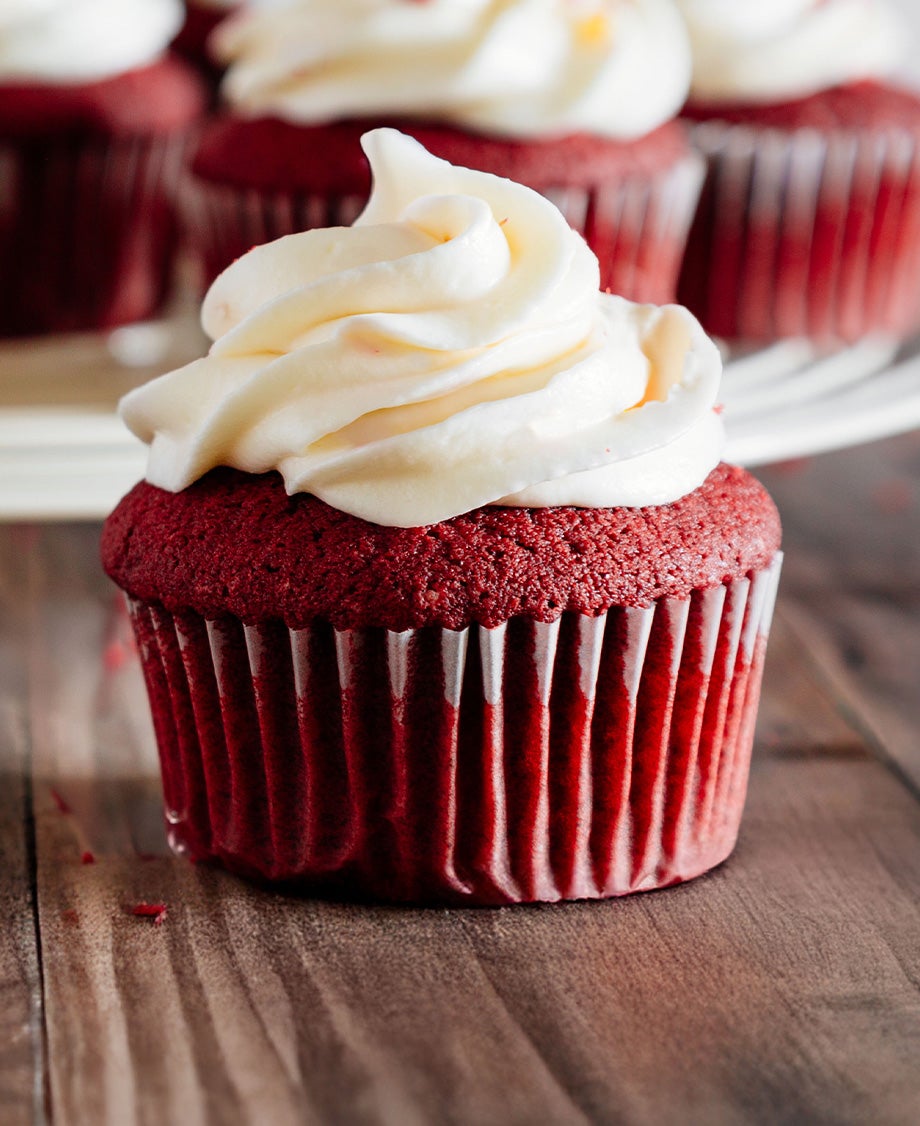 Red velvet cupcakes with Milkybar white chocolate buttercream icing on a wooden board