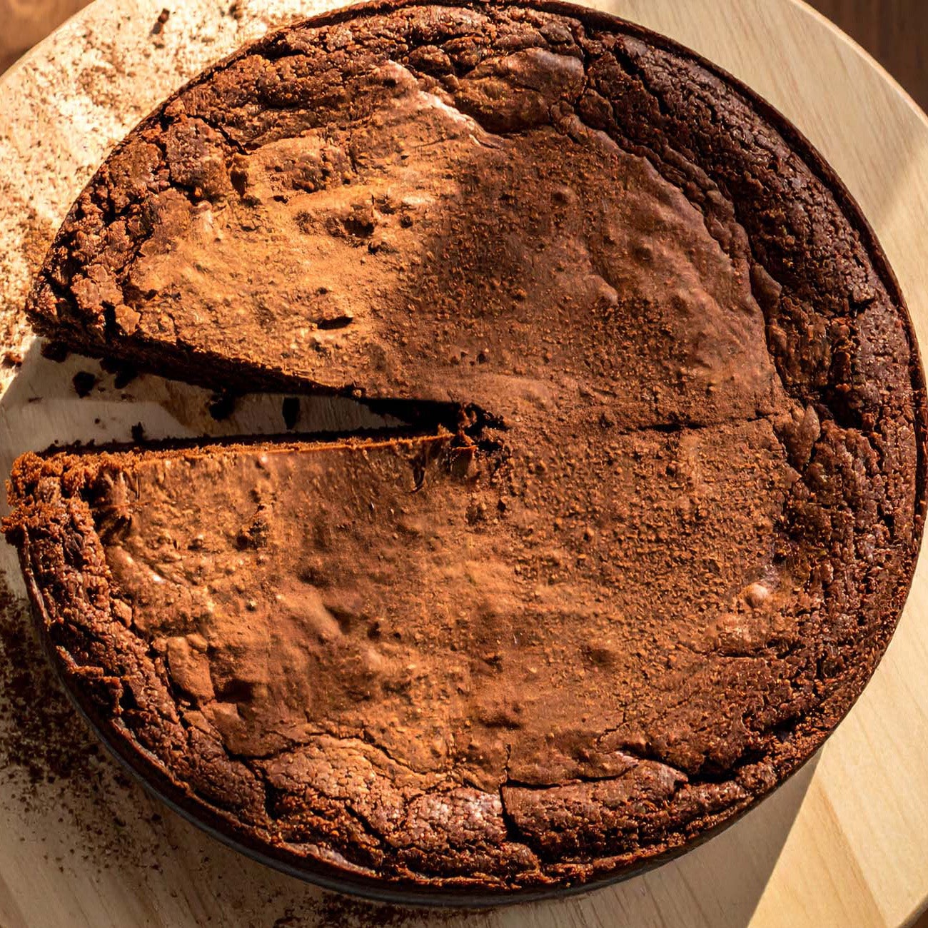 A round chocolate Flourless cake on a decorative plate.